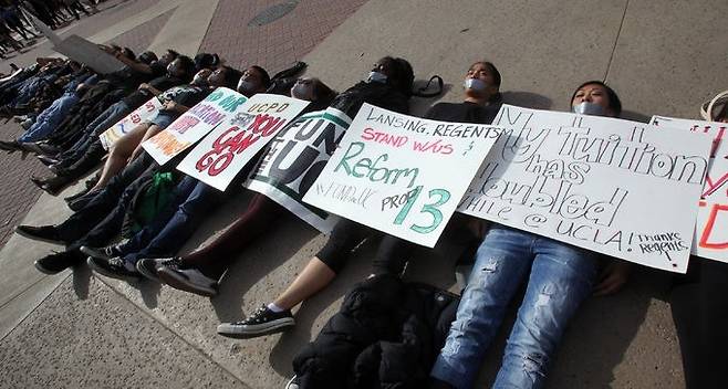 등록금 인상에 반대하는 미국 대학생들이 캠퍼스 길바닥에 드러누워 시위를 하는 모습. 세계일보 자료사진
