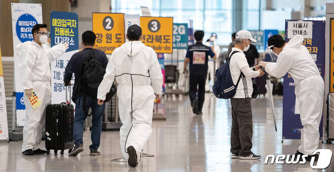 지난달 20일 인천국제공항 제1여객터미널 입국장에서 방역관계자들이 입국자들을 안내하고 있다. 2021.5.20/뉴스1 © News1 유승관 기자