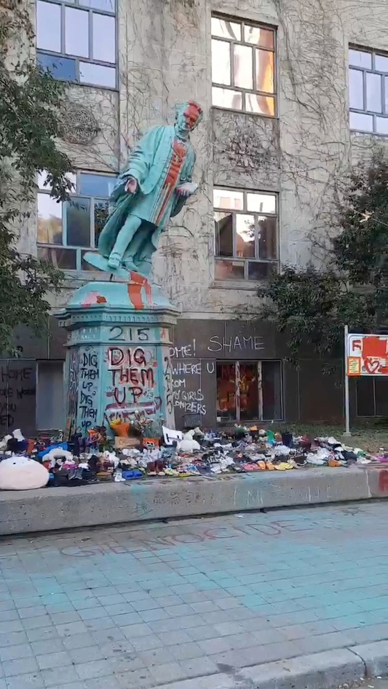 지난 6일(현지시간) 캐나다 토론토 라이어슨대에서 시위대가 라이어슨 목사의 동상을 끌어내리고 있다. 이튿날 훼손된 동상 일부는 개발반대 시위 현장에 옮겨졌다.〈사진=로이터〉