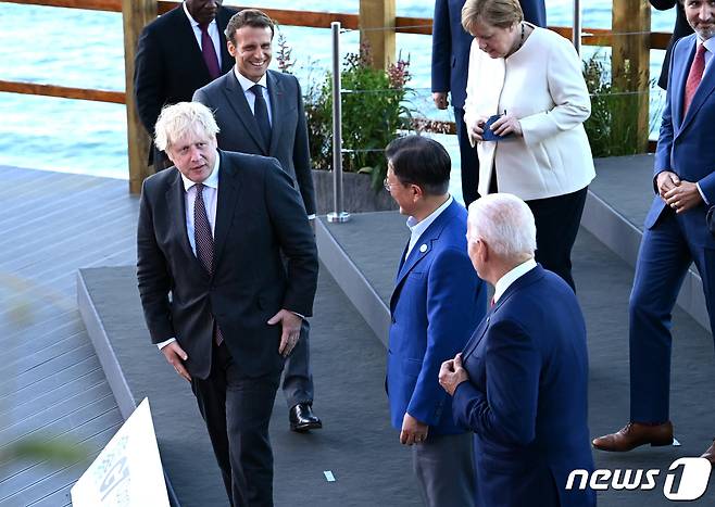G7 정상회의 참석차 영국을 방문한 문재인 대통령(앞줄 오른쪽 두 번째)이 12일(현지시간) 영국 콘월 카비스베이 양자회담장 앞에서 기념사진을 촬영하며 보리스 존슨 영국 총리와 대화를 나누고 있다.(G7 정상회의 제공) 2021.6.13/뉴스1