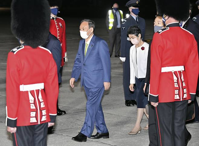 스가 요시히데 일본 총리 부부가 주요 7개국(G7) 정상회의 참석을 위해 6월11일(현지 시각) 마스크를 착용한 채 영국 세인트모건의 콘월 공항에 도착하고 있다. ⓒ 연합뉴스