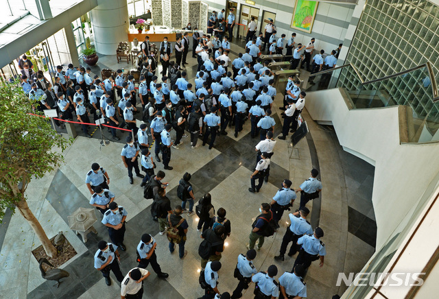 [홍콩=AP/뉴시스]17일 홍콩 대표적 반중매체 핑궈르바오 본사 건물에서 경찰관들이 모여있다. 경찰은 이날 라이언 로 편집장을 체포하고 본사를 급습해 증거자료를 압수했다. 2021.06.17