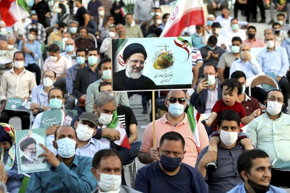 [테헤란=AP/뉴시스]에브라힘 라이시 이란 대통령 후보 지지자들이 14일(현지시간) 테헤란에서 열린 선거 유세에 참석해 그의 서명이 담긴 사진을 들고 있다. 강경 보수 성향 성직자인 라이시 후보는 최근 이란 국영 TV가 진행한 대선 여론조사에서 압도적으로 1위를 기록했다. 이란 대선은 오는 18일 치러진다. 2021.06.15. /사진=뉴시스