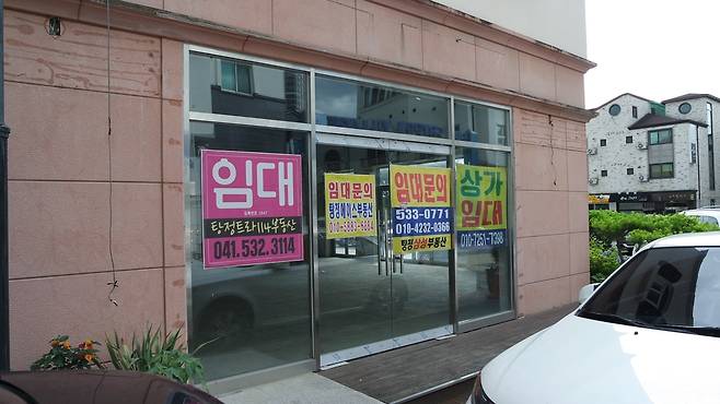 지중해 마을 거리 상가에 임대문의 안내문이 붙어있는 모습