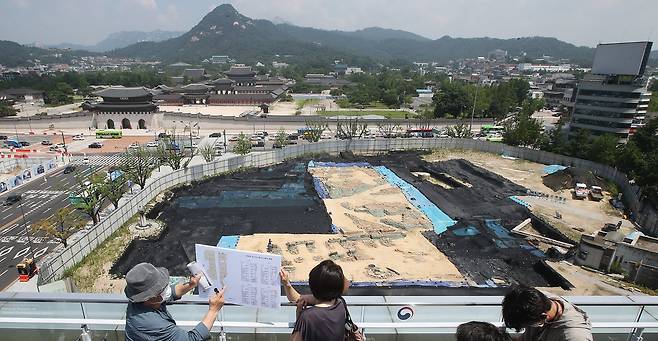 궁궐 박사 홍순민 교수(왼쪽)가 21일 서울시 종로구 대한민국역사박물관 옥상에서 옛 의정부 터 유적발굴 현장을 보면서 발굴과정을 설명하고 있다. 우상조 기자