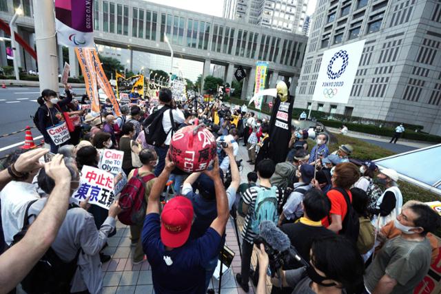 일본 도쿄에서 23일 코로나19 확산 위험을 이유로 다음 달 개최되는 도쿄올림픽 개최에 반대하는 시위대가 거리 행진을 하고 있다. 도쿄=AP 연합뉴스