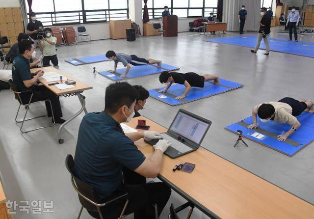 의무경찰 시험 응시생들이 25일 서울 중구 서울경찰청 기동본부에서 열린 마지막 선발시험에서 팔굽혀펴기를 하고 있다. 응시생들은 신종 코로나바이러스 감염증(코로나19) 확산 예방을 위해 마스크와 비닐 장갑을 낀 채 시험에 임했다. 고영권 기자