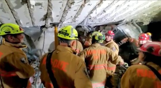 구조대원들이 붕괴한 아파트 지하 주차장에서 구조활동을 벌이고 있다. 로이터=연합뉴스