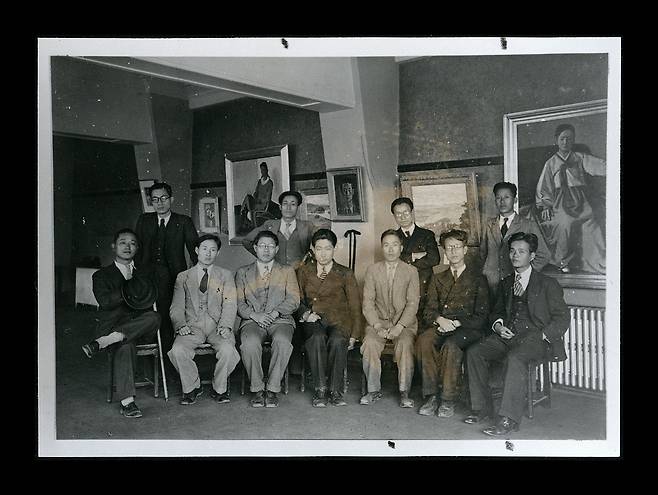 1935년 열린 김종태 유작전 기념 사진. 뒷줄 맨 왼쪽 안경 낀 사람이 정무묵이다. 전시장 중간에 작품 ‘석모 주암산’이 걸린 게 보인다. /국립현대미술관