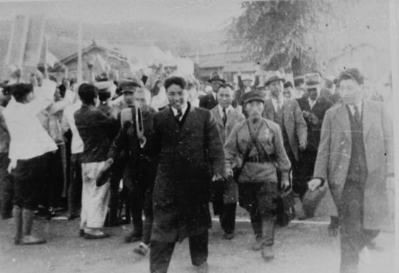 1946년 소련 군정 하의 북한 평양에서 친탁 시위장으로 가고 있는 당시 김일성(가운데 모자를 손에 든 사람)의 모습. [중앙포토]