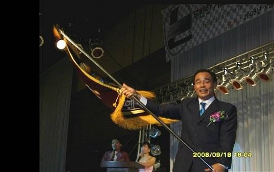 2008년 9월 한 행사장에서 조희팔이 깃발을 흔들고 있다. 사진 바른가정경제 실천을 위한 시민연대