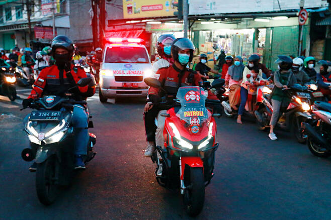 인도네시아에서 코로나19 응급환자를 이송하는 구급차가 교통체증이 심한 구간을 빠르게 이동할 수 있도록 길을 터주는 자원봉사를 하는 ‘오토바이 부대’의 모습. 사진 로이터 연합뉴스