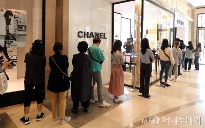 지난해 5월 롯데백화점 본점 샤넬 매장 앞에서 샤넬 매장에 들어가기 위해 번호표를 받으려는 고객들이 줄을 서고 있다/사진=이기범 기자