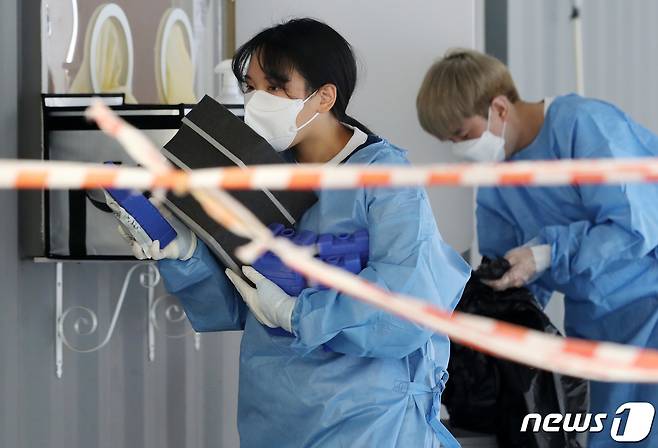 1년 중 더위가 가장 심하다는 절기 '대서'인 22일 오전 경기도 고양시 화정역 광장 선별진료소에서 한 의료진이 아이스팩을 챙겨 동료들에게 나눠주고 있다. 2021.7.22/뉴스1 © News1 이동해 기자