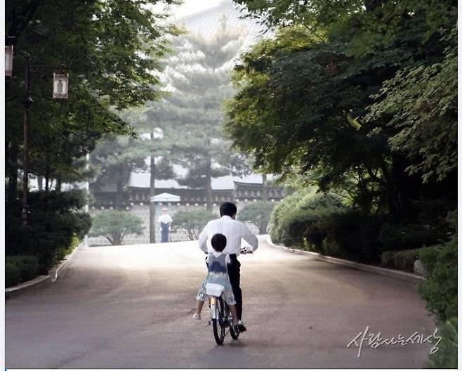 고 노무현 전 대통령이 손녀를 자전거에 태우고 청와대 경내를 돌고 있는 모습. (사람사는 세상 노무현재단 제공) © 뉴스1