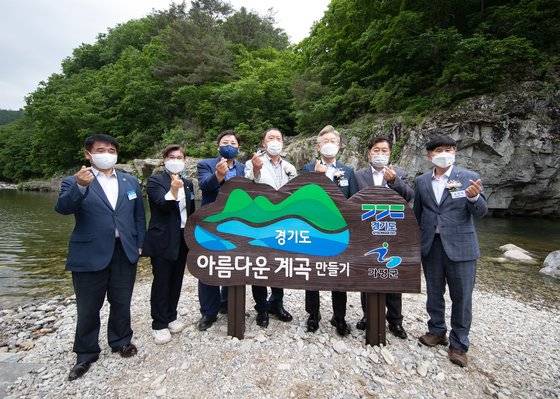 이재명 경기지사(오른쪽에서 세번째)가 지난해 5월 26일 경기도 가평군 북면 용소폭포에서 열린 경기도 청정계곡 생활SOC 준공식에서 정비된 계곡을 돌아본 뒤 기념촬영하고 있다. 경기도