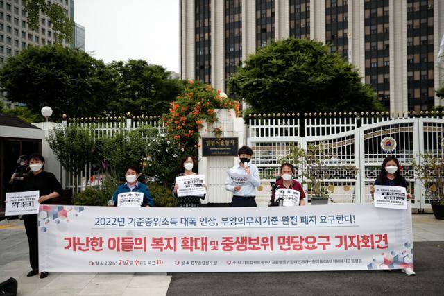 기초생활보장법바로세우기공동행동 구성원들이 지난 7일 정부서울청사 앞에서 기자회견을 열어 가난한 이들의 복지 확대와 빈곤문제 해결을 위해 2022년 기준 중위소득 대폭 인상을 요구하고 있다. 뉴스1