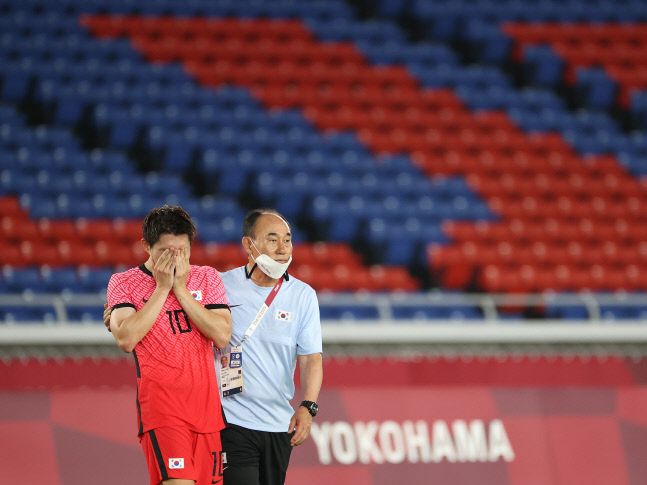 김학범(오른쪽) 올림픽축구대표팀 감독이 지난달 31일 요코하마 국제경기장에서 열린 도쿄올림픽 남자축구 8강전 멕시코전에서 3-6 완패한 뒤 눈물을 흘리는 이동경을 위로하고 있다. 요코하마 | 연합뉴스