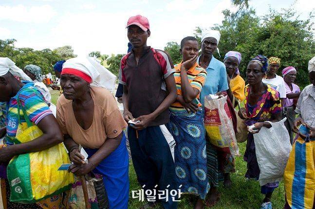 전문가들은 국제사회 원조를 받던 한국이 선진국 대열에 합류한 만큼 앞으로 빈곤국과 개발도상국에 대한 원조에 적극 나설 의무가 있다고 강조한다. 사진은 짐바브웨 수도 하라레 북동쪽 약 230㎞ 떨어진 무지(Mudzi) 마을에서 주민들이 식량 배급을 받기 위해 배급표를 들고 줄 서 있는 모습. ⓒ뉴시스