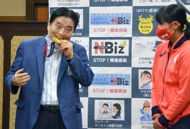 가와무라 다카시 일본 나고야 시장(왼쪽)이 지난 4일 나고야시청을 방문한 도쿄올림픽 소프트볼 금메달리스트 고토 미우의 메달을 양해도 구하지 않은 채 깨물고 있다. 나고야/교도연합뉴스