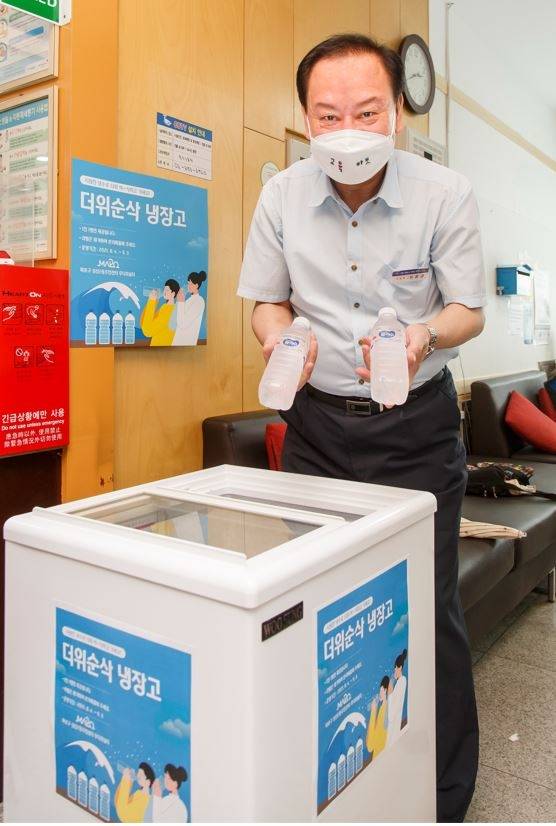 더위순삭 냉장고에 생수를 채워 넣고 있는 유동균 마포구청장. 사진=마포구