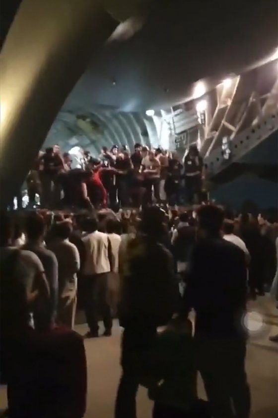 입구가 일부 열려 있던 C-17 수송기에 아프간 난민들이 탑승하고 있다. [트위터]