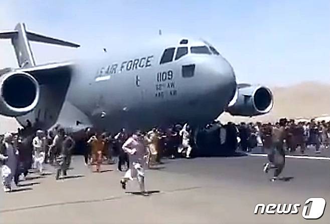 16일(현지시간) 시민들이 아프가니스탄 탈출을 위해 찾은 카불 국제공항에서 달리는 비행기에 올라타기 위해 뛰고 있다. (트위터 캡쳐) 2021.8.16/사진=뉴스1