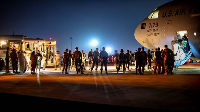 아프간 피난민들이 2021년 8월 24일 쿠웨이트 알리 알 살렘 공군기지에 도착한 후 미국 C-17 글로벌 마스터를 떠나고 있다. 쿠에이트 | 로이터연합뉴스