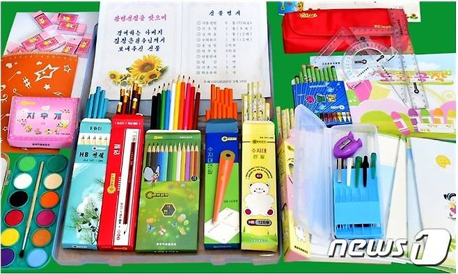 2020년, 2021년 유치원, 소학교 입학을 앞두고 김정일 위원장 생일인 2월에 제공된 용봉학용품공장의 <해바라기>표 학용품들. 사진에서 보이는 선물명세서에도 해바라기 그림이 그려져 있고, 학용품들 포장에도 <해바라기>상표가 인쇄되어 있다. 용봉학용품공장은 수지대연필, 지우개, 원주필(볼펜), 필통, 자와 미술용품인 크레용, 수채화물감 등을 만드는 생산기지로 알려져 있다. 최근 이 공장에서 생산되는 학용품들은 과거에 비해 색감이 파스텔톤을 넣어 다양해지고, 아동화 기법의 이미지들을 활용해 포장에 생기를 넣은 특징을 보인다. (<조선의 오늘> 갈무리) © 뉴스1