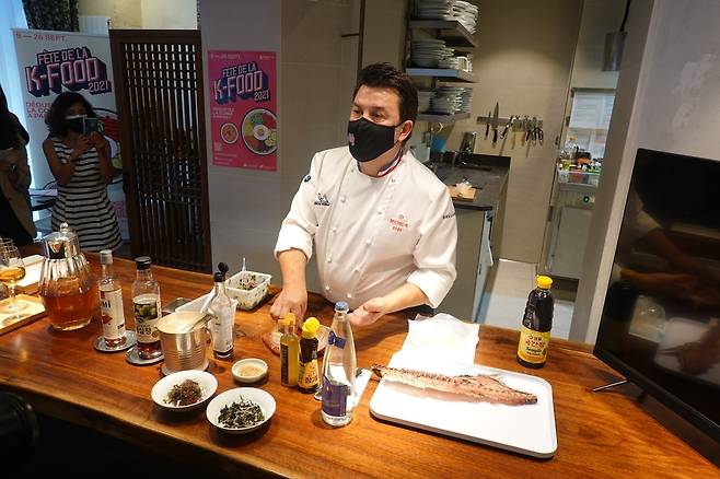 한국 식자재 소개하는 에릭 트로숑 프랑스 셰프 (파리=연합뉴스) 현혜란 특파원 = 프랑스 파리에서 한국농수산식품유통공사(aT) 파리지사가 30일(현지시간) 개최한 'K-푸드 상품설명회'에서 미슐랭 1스타 레스토랑 '솔스티스'를 운영하는 에릭 트로숑 셰프가 국간장, 참기름, 참깨 등 한국 식자재를 사용하는 방법을 현지 셰프들에게 소개하고 있다. 2021.8.30 runran@yna.co.kr