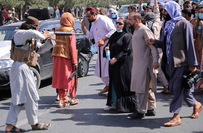 7일 아프가니스탄 수도 카불 파키스탄 대사관 근처에서 열린 반 파키스탄 시위 도중 한 탈레반 병사가 시위대에 총구를 겨누고 있다./로이터 연합뉴스