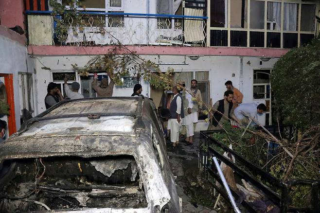 미군이 지난달 29일(현지시간) 자폭 테러범들을 싣고 아프가니스탄 카불공항으로 향하던 차량을 겨냥한 무인기 공격을 단행했다. 사진은 미군 폭격을 단행한 이후 주민들이 현장을 둘러보고 있는 모습. AP 연합뉴스