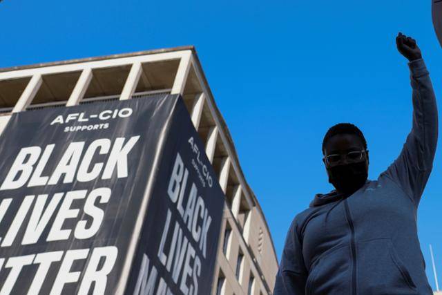 한 흑인 시위자가 4월 20일 미국 워싱턴 '흑인 목숨도 소중하다(BLM)' 광장에서 흑인 조지 플로이드 살해 혐의로 기소된 경찰관 데릭 쇼빈의 유죄 평결에 기뻐하고 있다. 워싱턴=로이터 연합뉴스