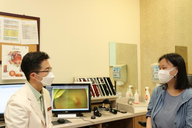 김상진(왼쪽) 삼성서울병원 안과 교수가 국내 처음으로 유전자 치료제인 럭스터나를 투여해 유전성 망막 변성 환자를 치료했다. 김 교수가 환자를 진료하는 모습. 삼성서울병원 제공
