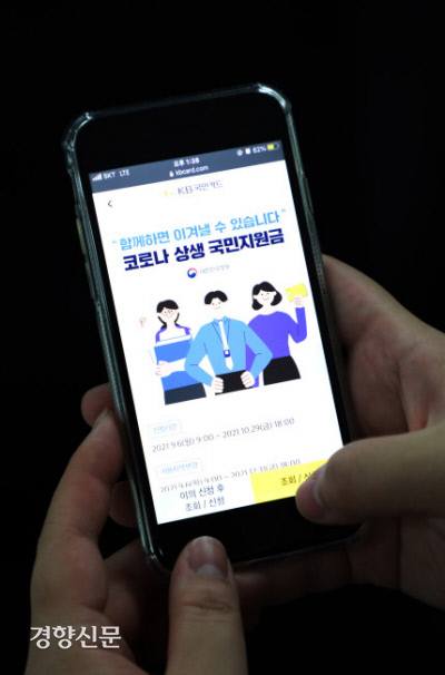 한 시민이 스마트폰으로 카드사 애플리케이션을 통해 코로나 상생 국민지원금 신청을 하고 있다. 김영민 기자