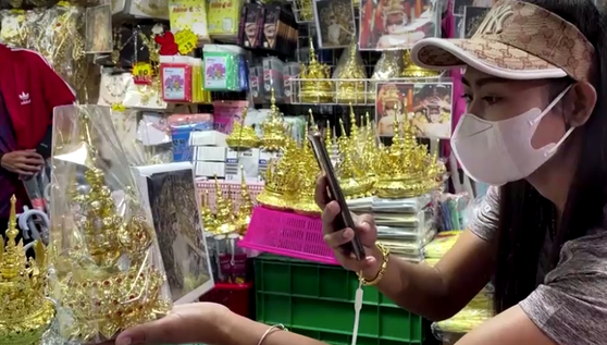 태국 현지 전통시장에서 리사가 착용한 태국 전통 머리 장식을 구경하고 있는 태국인. 〈화면출처=로이터 통신〉
