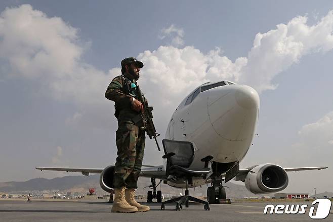 12일(현지시간) 아프가니스탄 카불 공항에서 탈레반 병사가 아리아나 아프간 항공의 비행기를 경비하고 있다. © AFP=뉴스1 © News1 우동명 기자