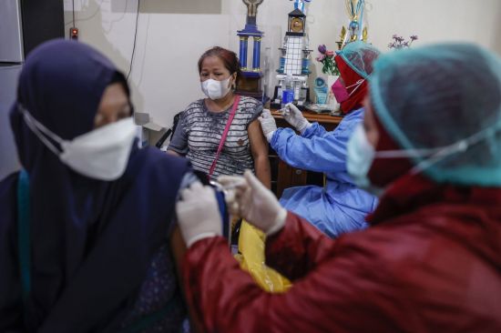 인도네시아의 한 여성이 화이자 코로나19 백신을 접종하고 있다. [이미지출처=EPA연합뉴스]