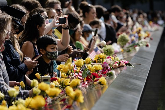 뉴욕 국립 9·11 기념관 및 박물관에서 9·11 테러 20주년을 맞아 열린 기념식에서 사람들이 희생자를 추모하고 있다. [AP=연합뉴스]