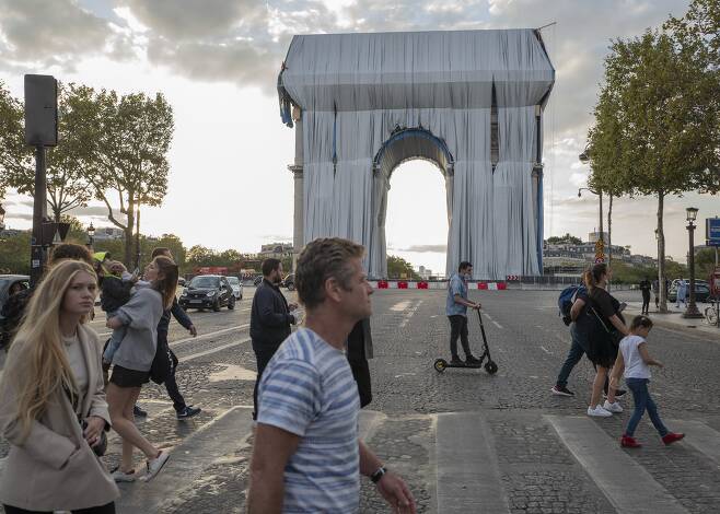 파리 시민들이 12일 둘러싸기 프로젝트가 진행 중인 개선문 앞을 지나고 있다. AP=연합뉴스