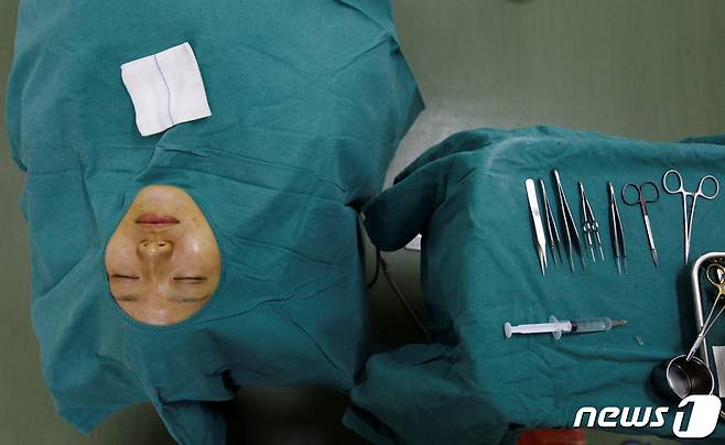 중국 상하이의 한 성형외과에서 쌍꺼풀 수술을 받으려는 환자가 누워서 대기중이다. © 로이터=뉴스1