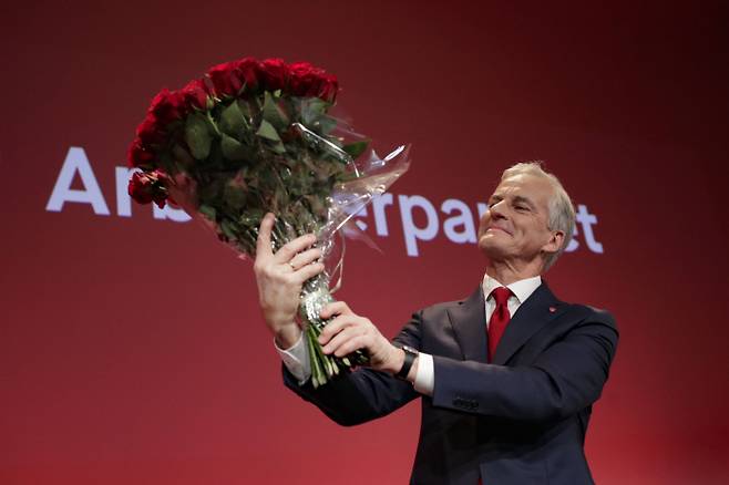 조나스 가르 스토에르 노르웨이 노동당 대표가 13일(현지시간) 총선에서 좌파 연정의 승리가 확정된 후 오슬로 노동당 당사에서 꽃다발을 들어올리고 있다. 오슬로|AP연합뉴스