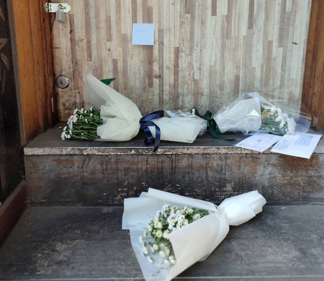 호프집 출입문 앞에 놓인 추모 꽃다발들 /사진=정세진 기자