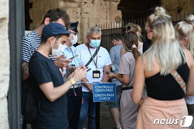 6일(현지시간) 이탈리아 수도 로마 소재 콜로세움 입구에서 관광객들이 백신 접종 증명서인 '그린패스'를 들고 줄을 서 있다. 2021.08.06 © AFP=뉴스1