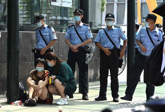 15일 중국 광둥성 선전시의 헝다그룹 본사 앞에서 '돈을 돌려달라'면서 투자자들이 시위를 하고 있다. 그 앞을 [AFP=연합뉴스]