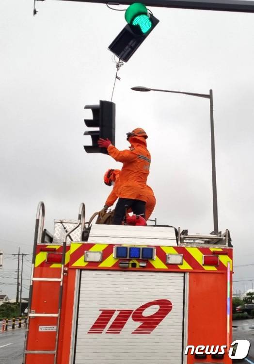 제14호 태풍 '찬투(CHANTHU)'가 북상 중인 17일 오전 6시52분쯤 제주시 한경면의 한 도로에서 차량 신호등이 파손돼 안전조치가 이뤄지고 있다.(제주도 소방안전본부 제공)2021.9.17/뉴스1 © News1 오미란 기자