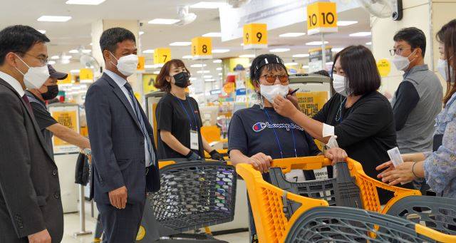 남군산교회 이신사 목사(맨 왼쪽)와 성도들이 지난 16일 이마트 군산점에서 쇼핑을 마치고 나온 지역 어르신을 섬기고 있다.