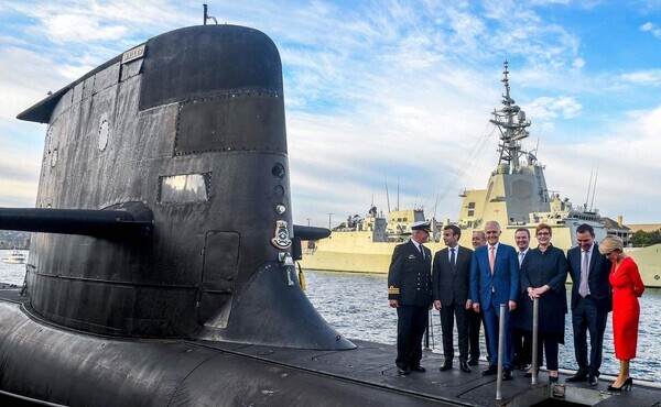 에마뉘엘 마크롱 프랑스 대통령(왼쪽 두 번째)과 맬컴 턴불 오스트레일리아 총리(가운데)가 2018년 5월 2일 시드니 가든 아일랜드에서 오스트레일리아 해군의 콜린스급 잠수함 ‘HMAS 웨일러’의 선체 위에 서 있다. 오스트레일리아는 15일(현지시각) 미국·영국과 3국간 안보협력체인 ‘오커스’의 발족과 함께 미국의 기술 지원으로 핵추진잠수함 개발에 나서면서, 프랑스와 추진해온 660억 달러(약 77조원) 규모의 재래식 잠수함 건조 계획을 철회할 것으로 예상된다. AFP 연합뉴스 자료사진