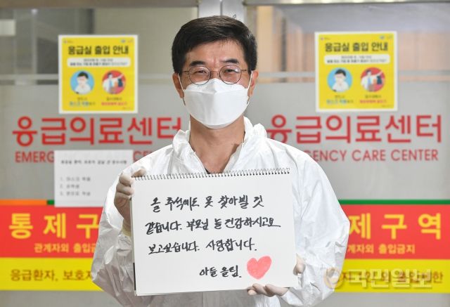 오인영 김포우리병원 응급센터장이 지난 7일 경기도 김포우리병원 응급의료센터 앞에서 충북 음성에 계신 부모님에게 보내는 메시지를 들고 있다.