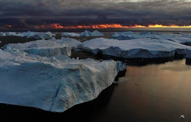 일루리삿 빙하에서 떨어져 나온 빙산이 석양을 배경으로 바다에 떠 있다. 로이터=연합뉴스